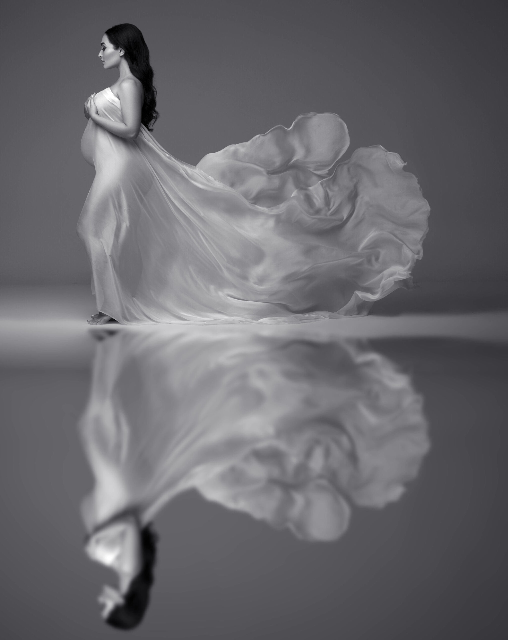 Fine-art maternity silhouette in studio with flowing silk fabric by Chicago maternity photographer